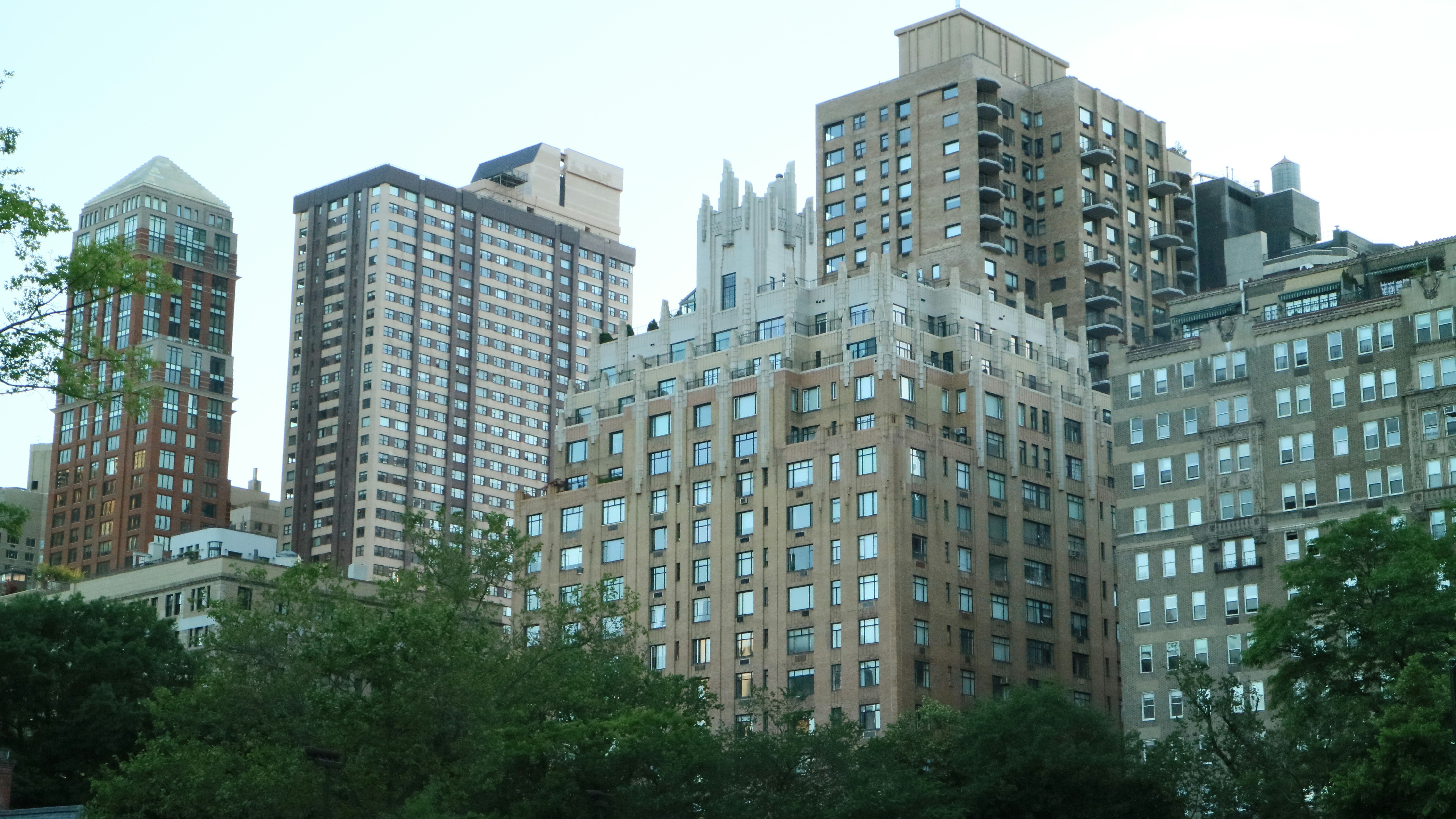 Brown high-rise buildings surrounded with tall and green trees photo ...