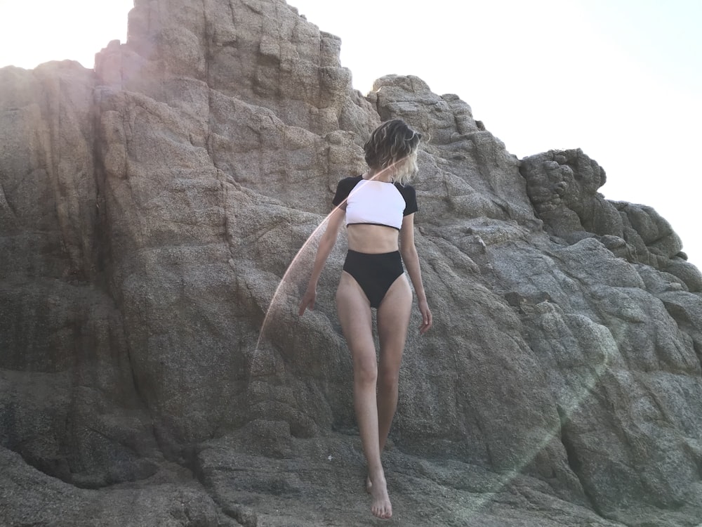 woman wearing black panties standing on brown rocks