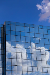 Elegant glass window installation on a modern commercial building with blue sky background.