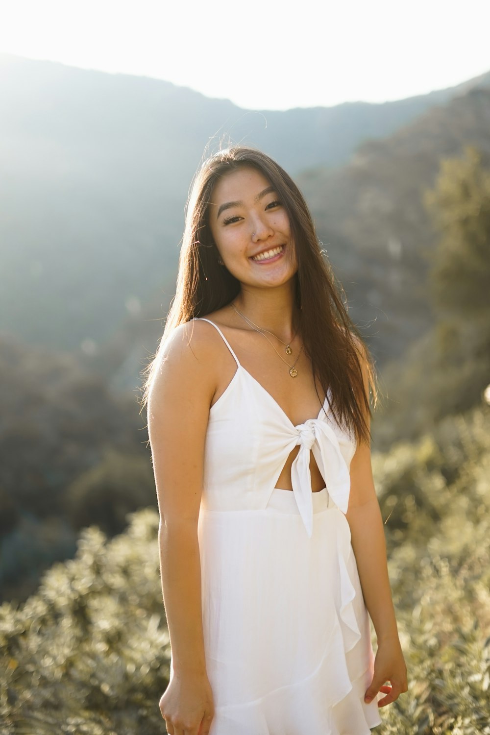 woman wearing white cami dress smiling during daytime