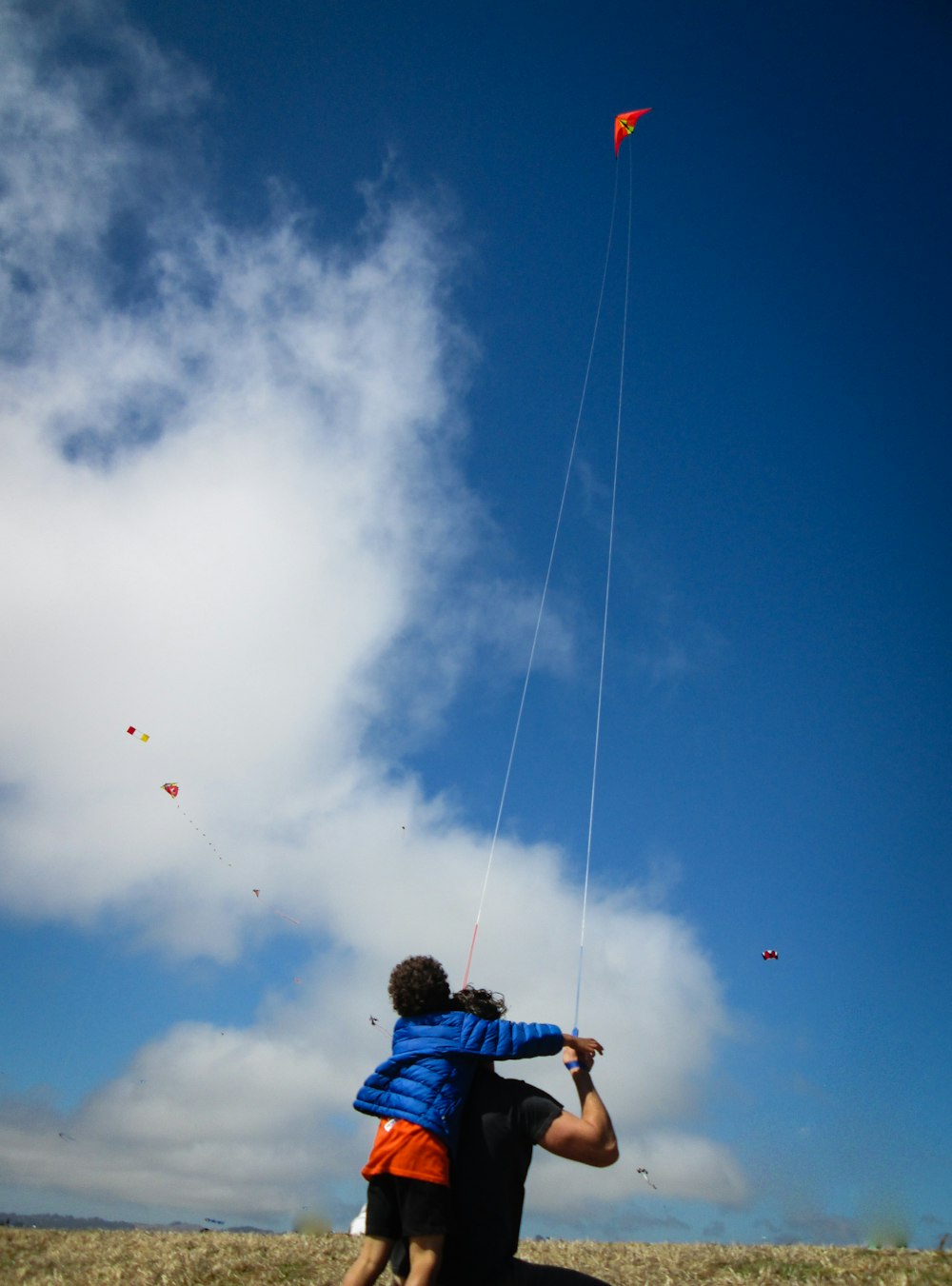 man and boy playing kite during daytime