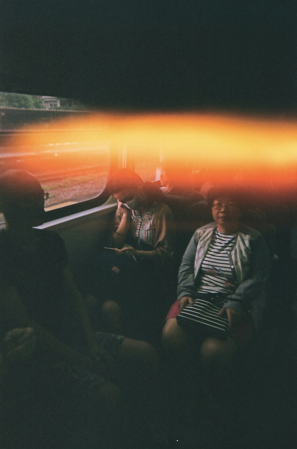 woman wearing brown jacket besides woman holding black and white stripe shirt