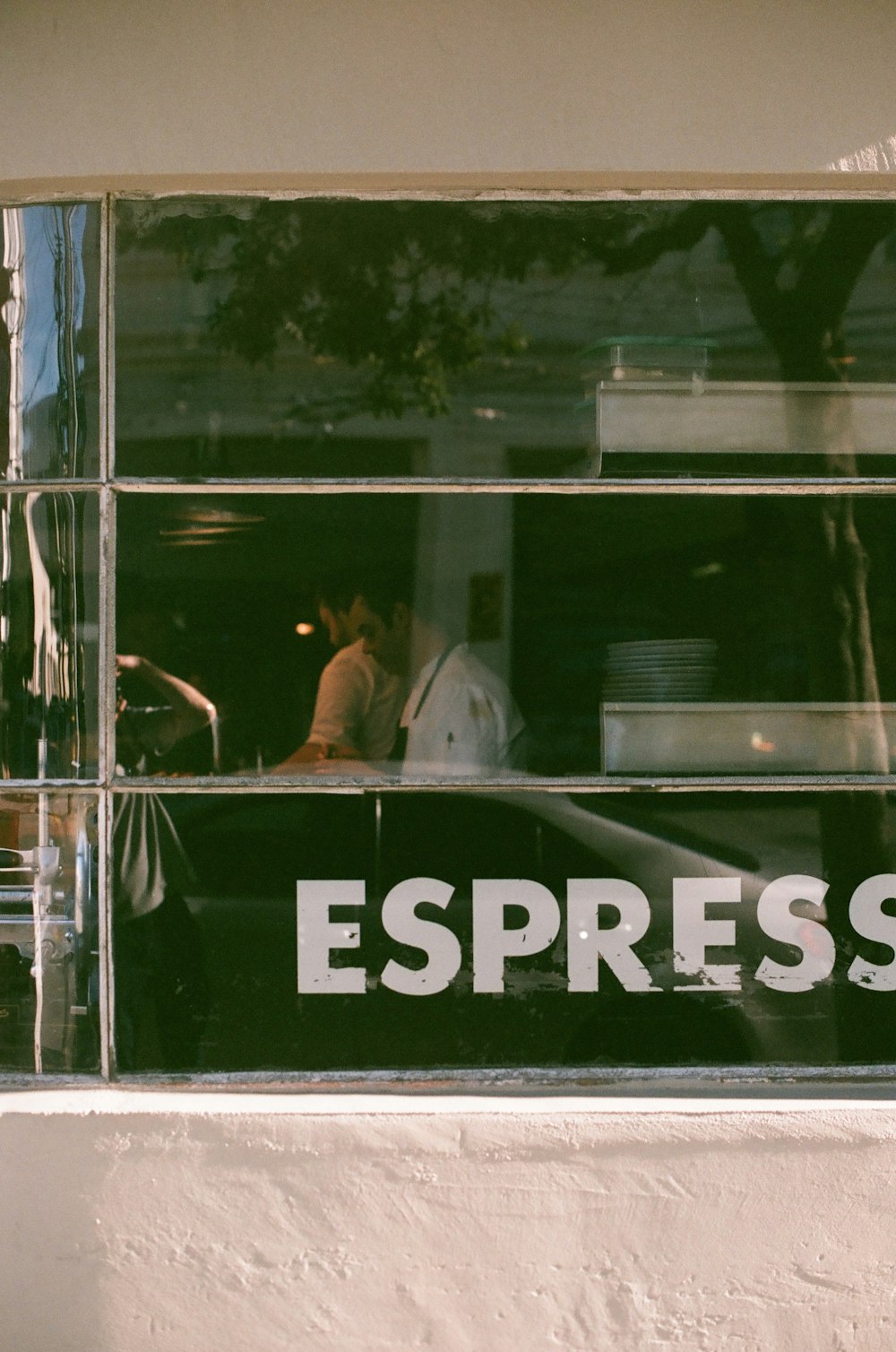 the reflection of a man and a woman in a window