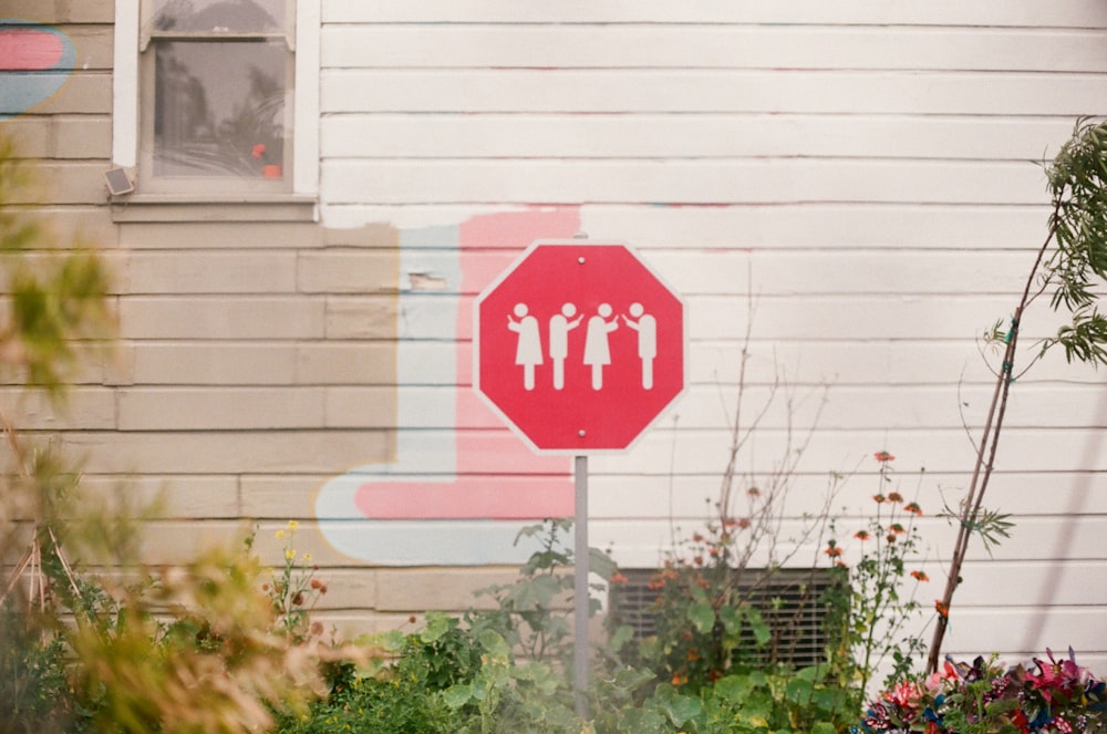 red and and white signage near white wall