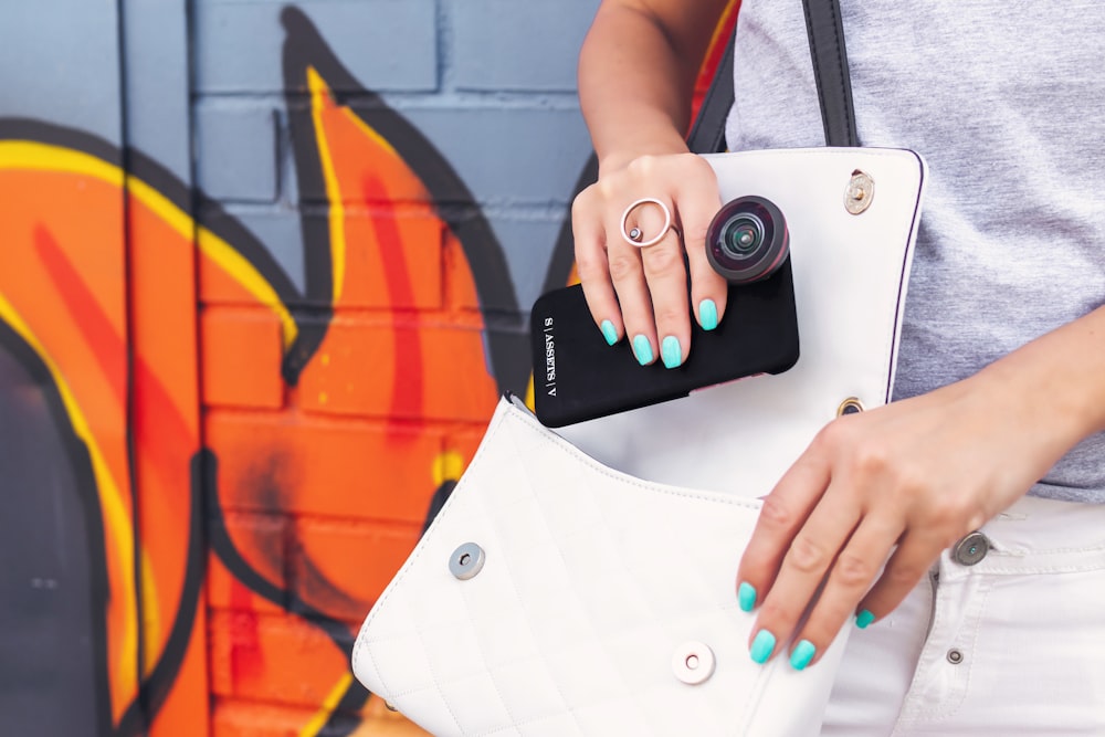 woman putting phone in bag