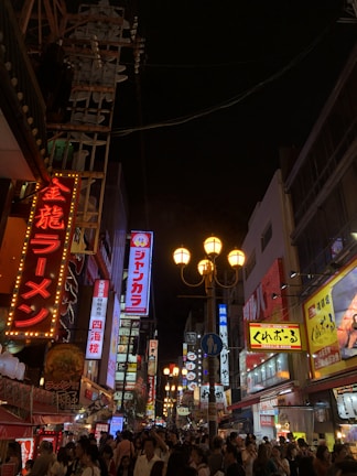 A bustling Tokyo street at night illuminated by glowing orange lanterns and neon signs