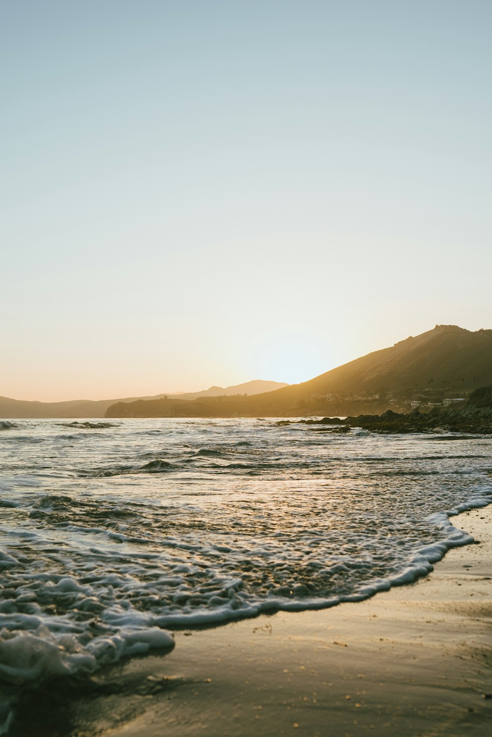 photography of seashore and mountain during sunset