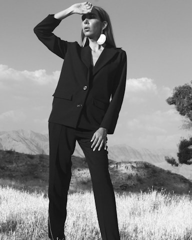 Portrait of Eleusa Gutemberg, a confident female land law attorney, standing in a rural farming field with plantations in the background.