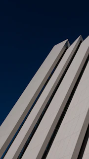 Wide shot of a modern engineering structure blending seamlessly with natural surroundings under a deep blue sky.