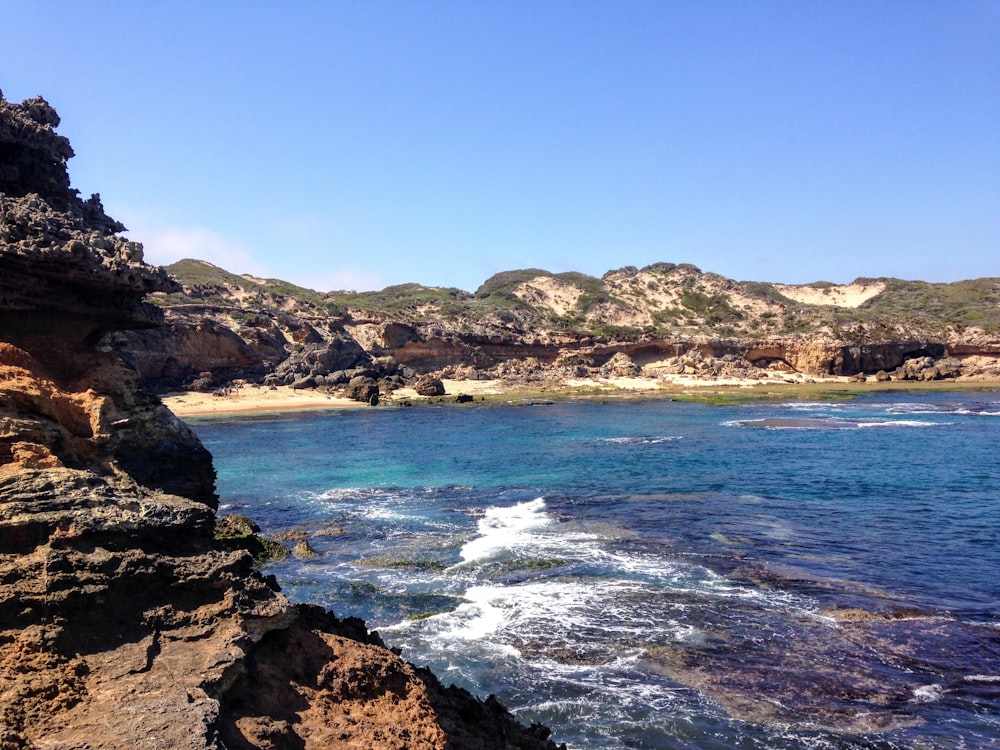 cliff near body of water during daytime