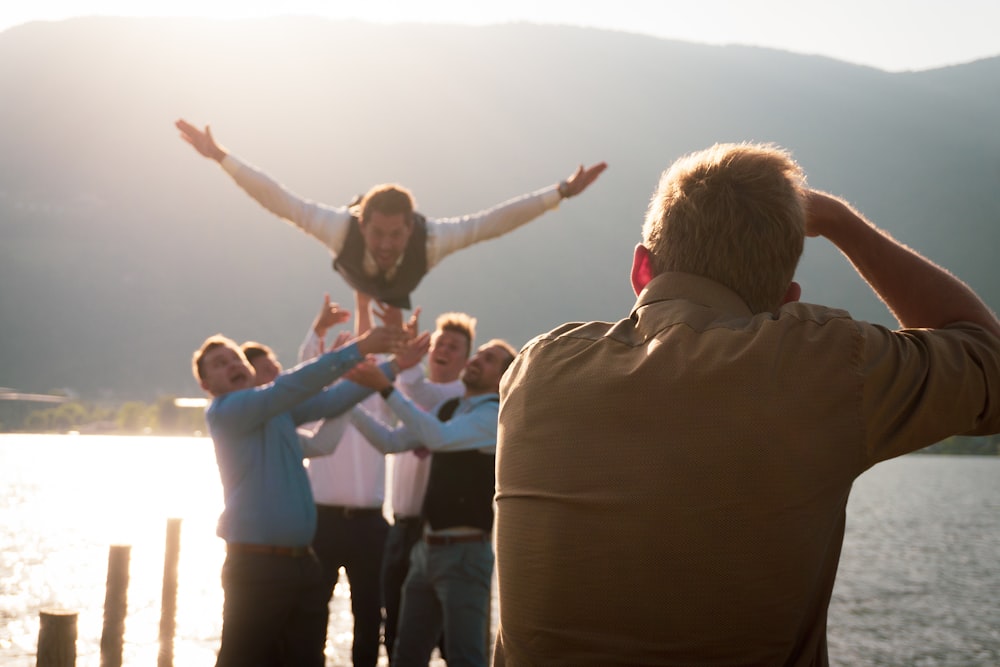 group of men beside body of water