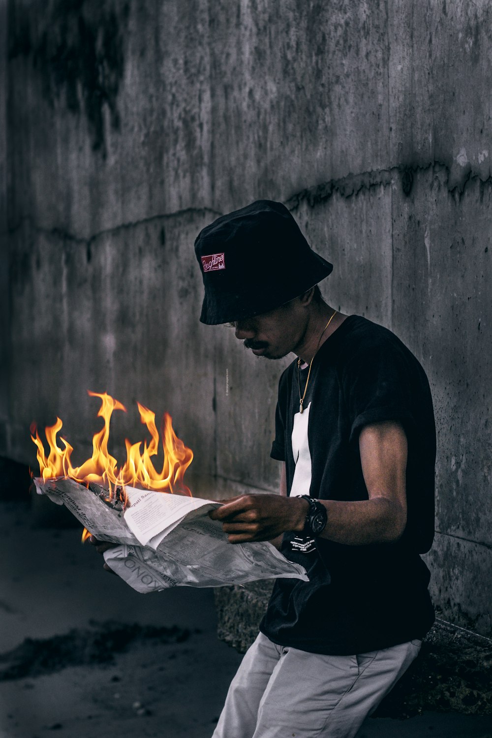 unknown person holding lit newspaper