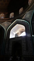 Sunlight filtering through intricate Islamic patterns inside the mosque prayer hall.