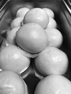 A tray of warm, soft buns with a light dusting of flour, ready to be enjoyed