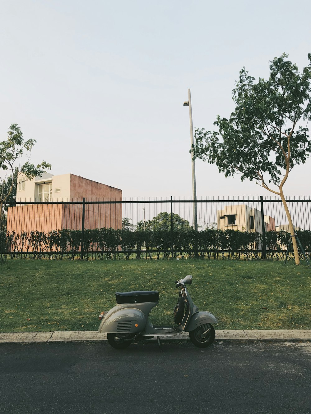 gray moped parked besides green grass