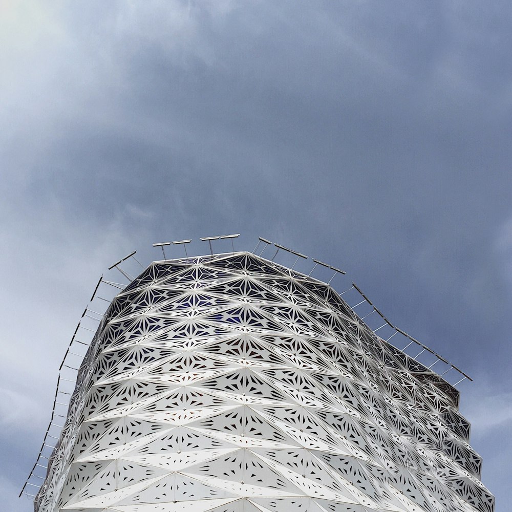 low-angle photo of gray building under white clouds