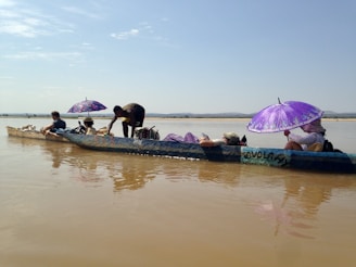 people riding blue wooden boat during daytime