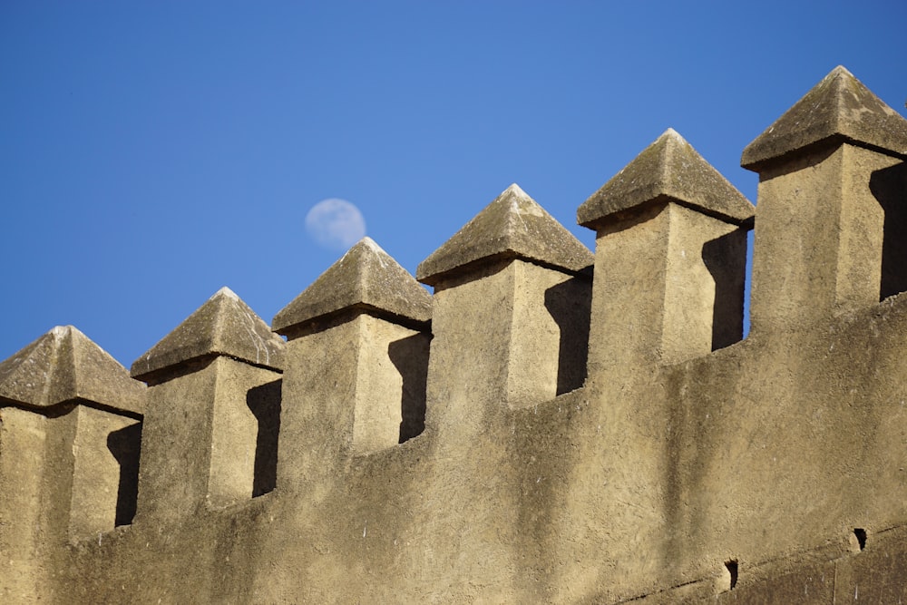 grey moon on blue sky above concrete wall