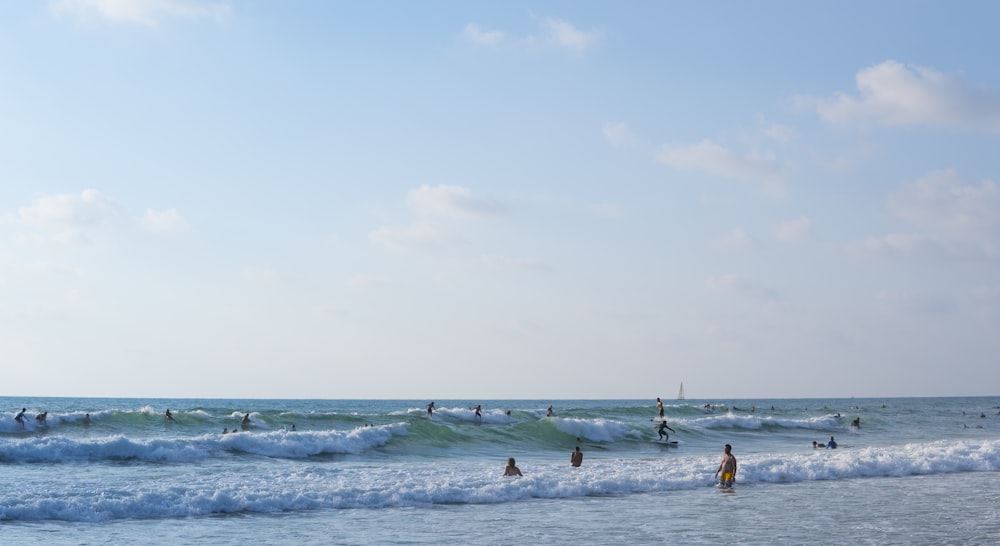 people on ocean under cloudy sky during daytime