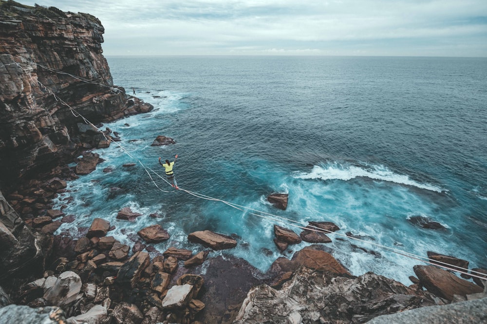 woman crossing the shore by balancing on the rope