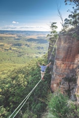 man walking on string over the hill during daytime