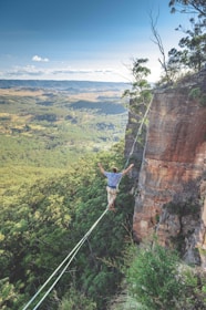 man walking on string over the hill during daytime