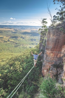 man walking on string over the hill during daytime