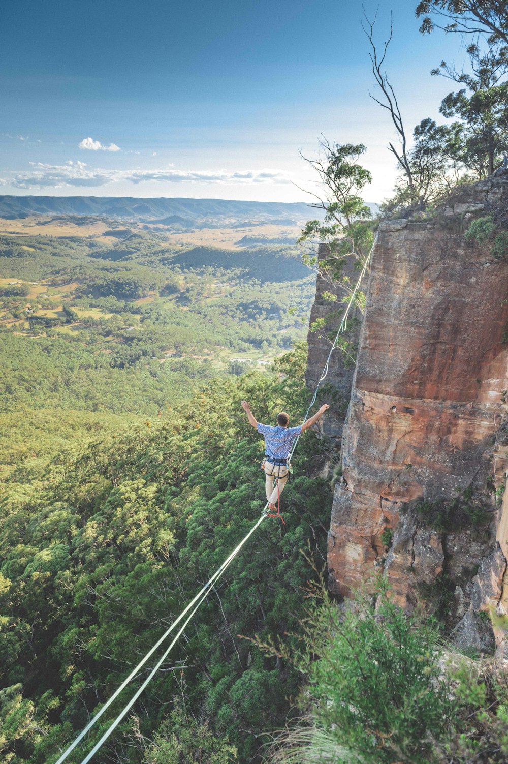 man walking on string over the hill during daytime