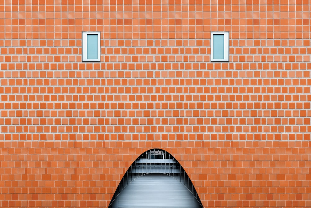 an orange brick building with a walkway going through it