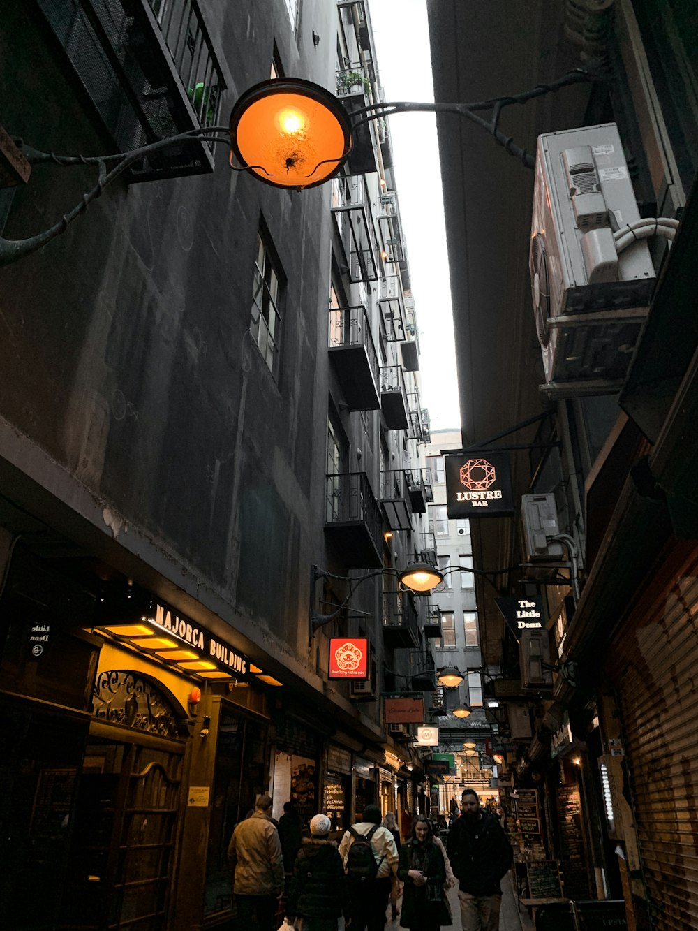 people walking near street beside high-rise buildings during night time