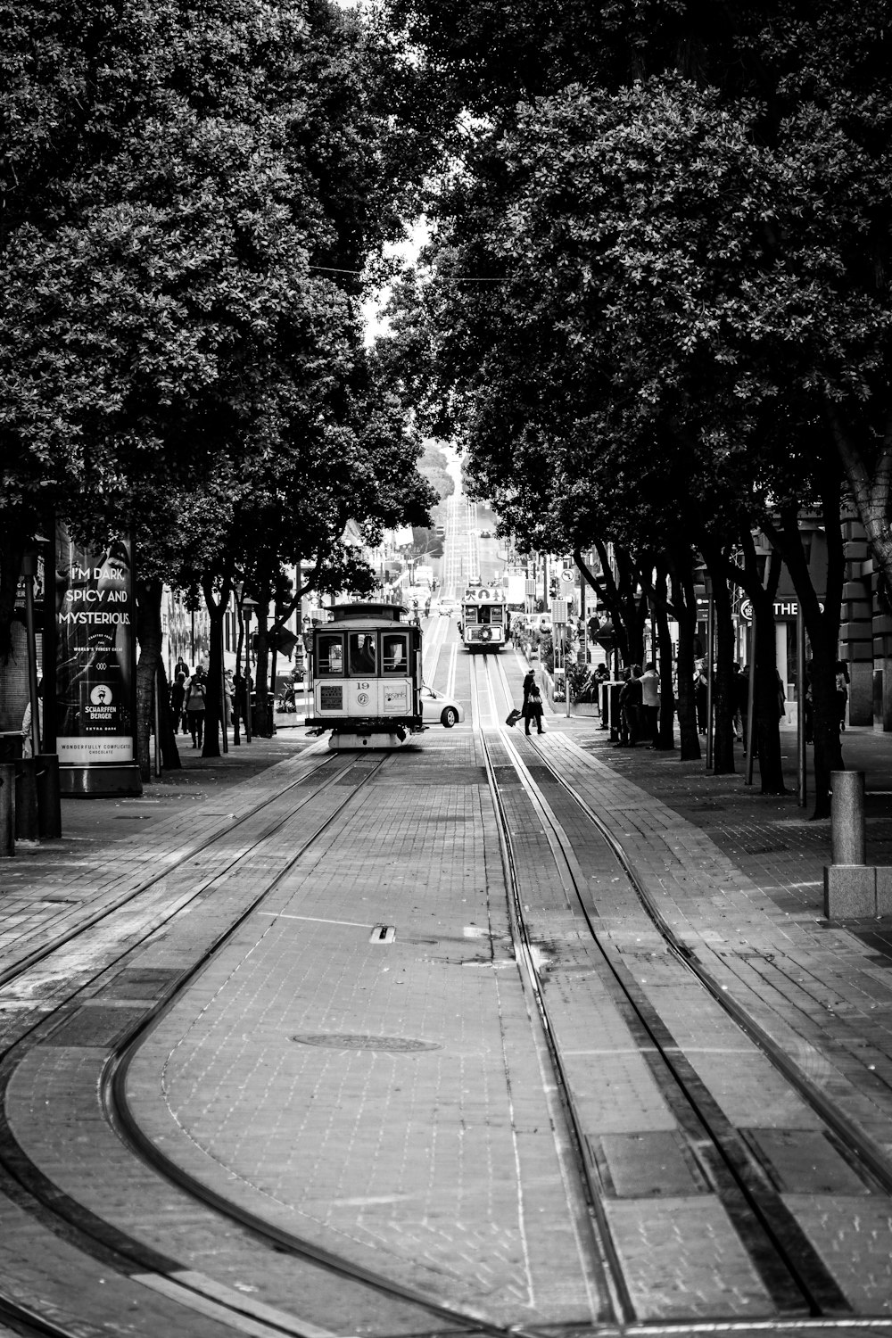 grayscale photo of people and tram in street