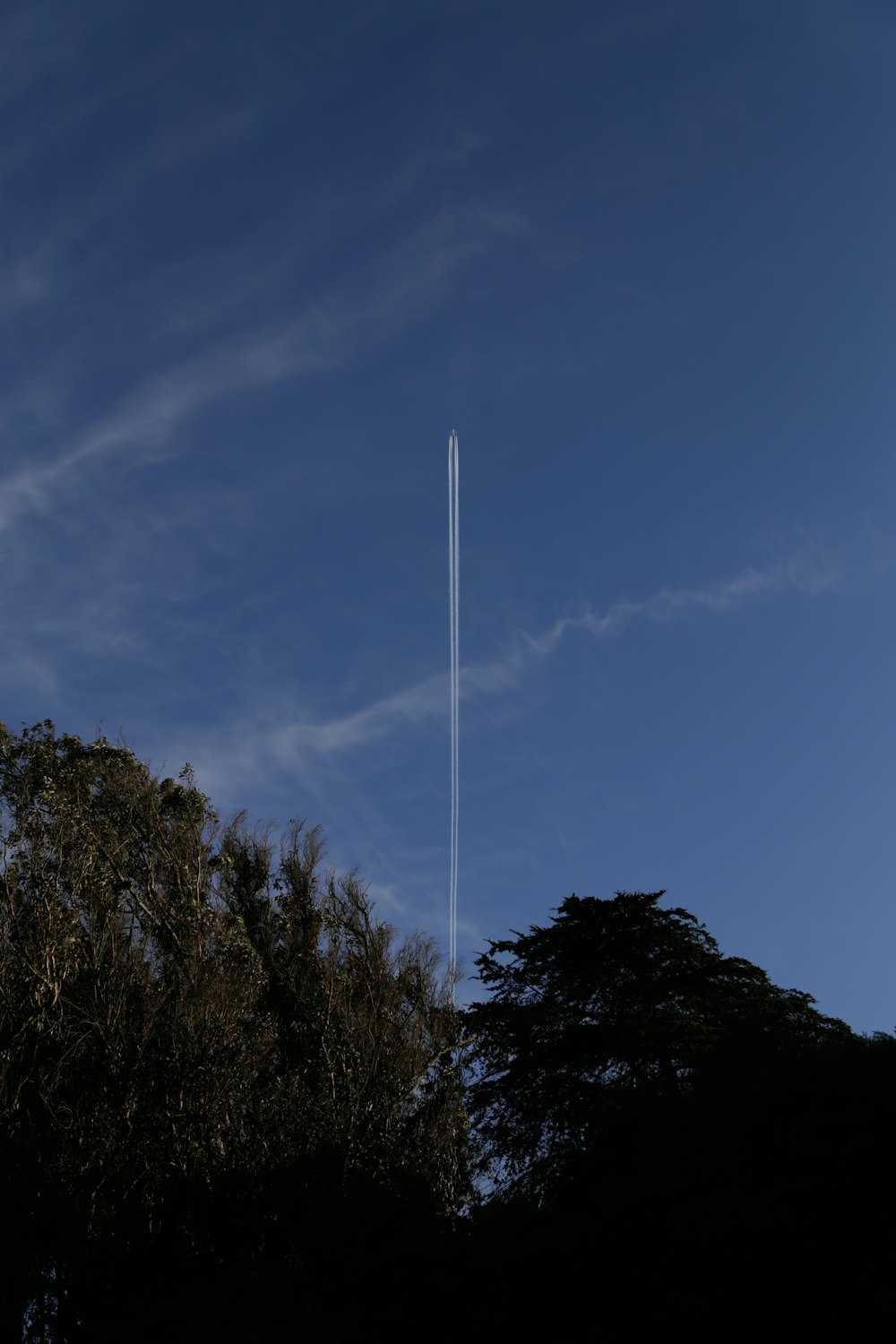 jet leaving white jetstream in blue sky