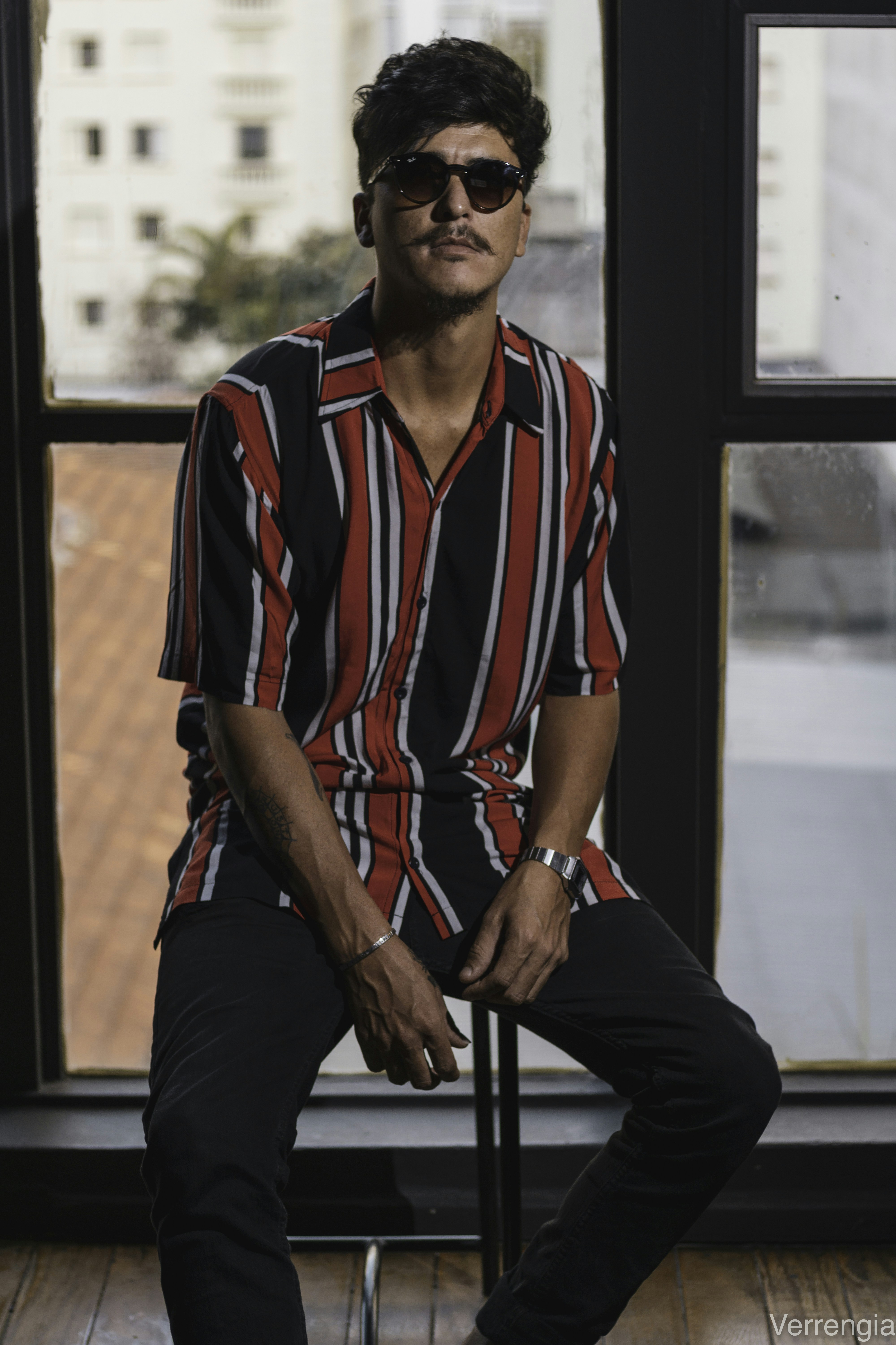 shallow focus photography of man sitting near window