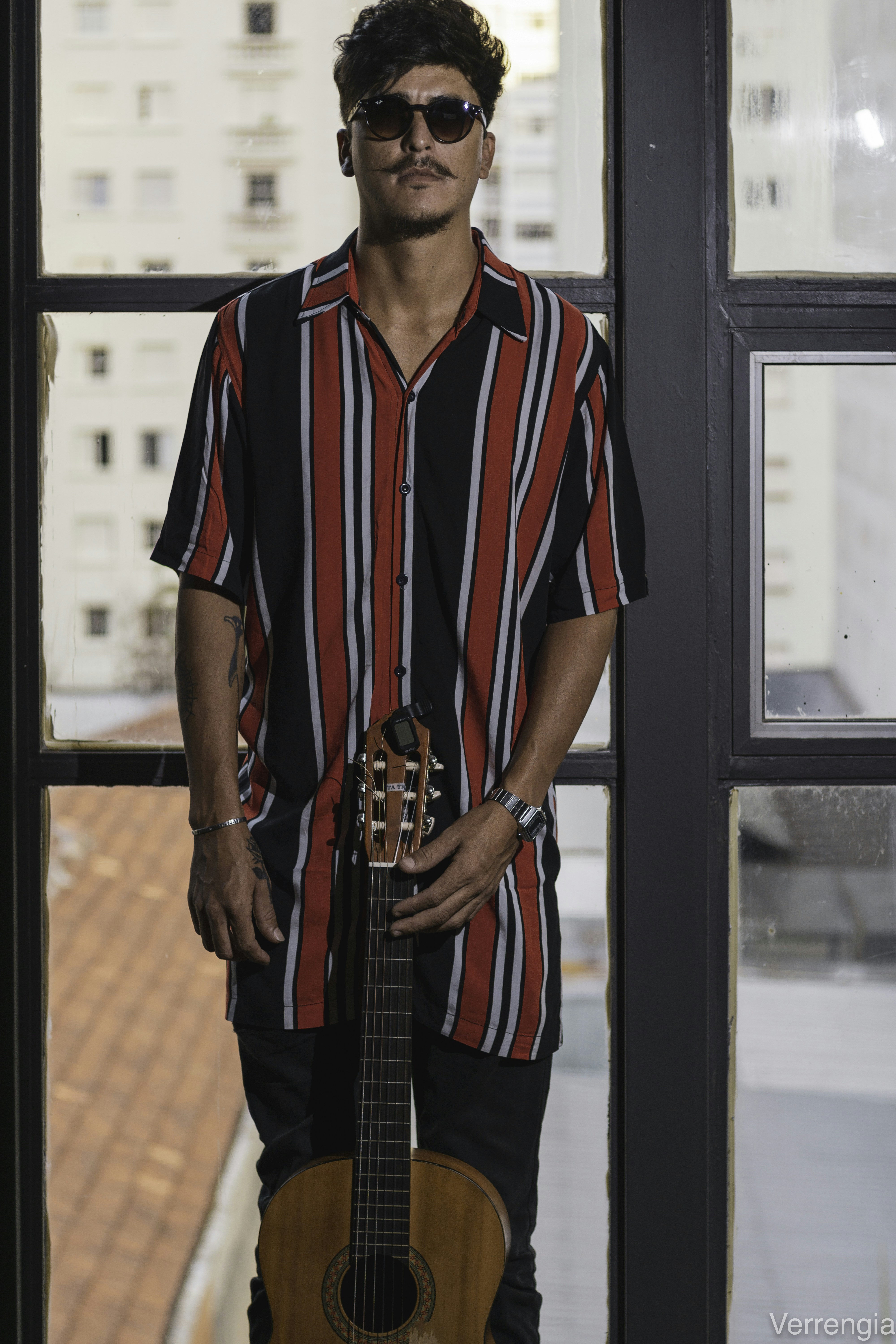 man with guitar standing in doorway