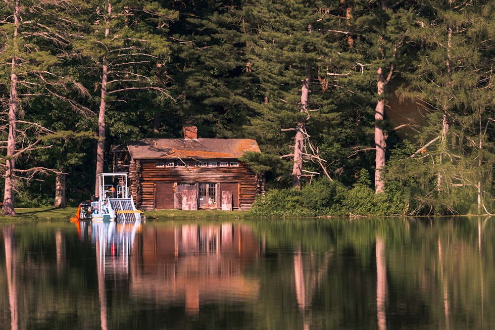 cabin in front of trees near the lake during day