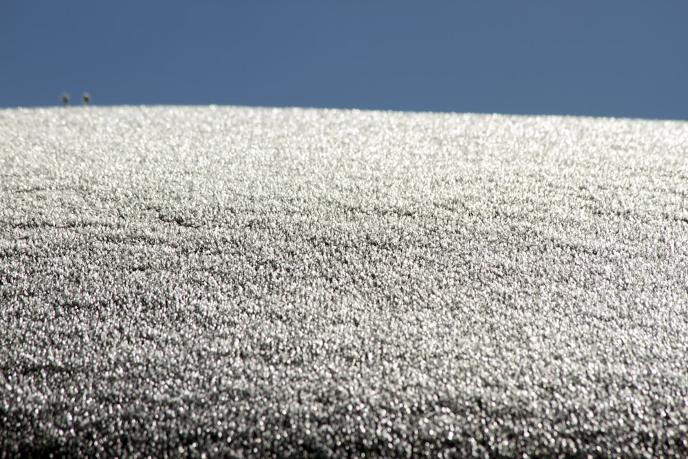 a hill covered in snow under a blue sky