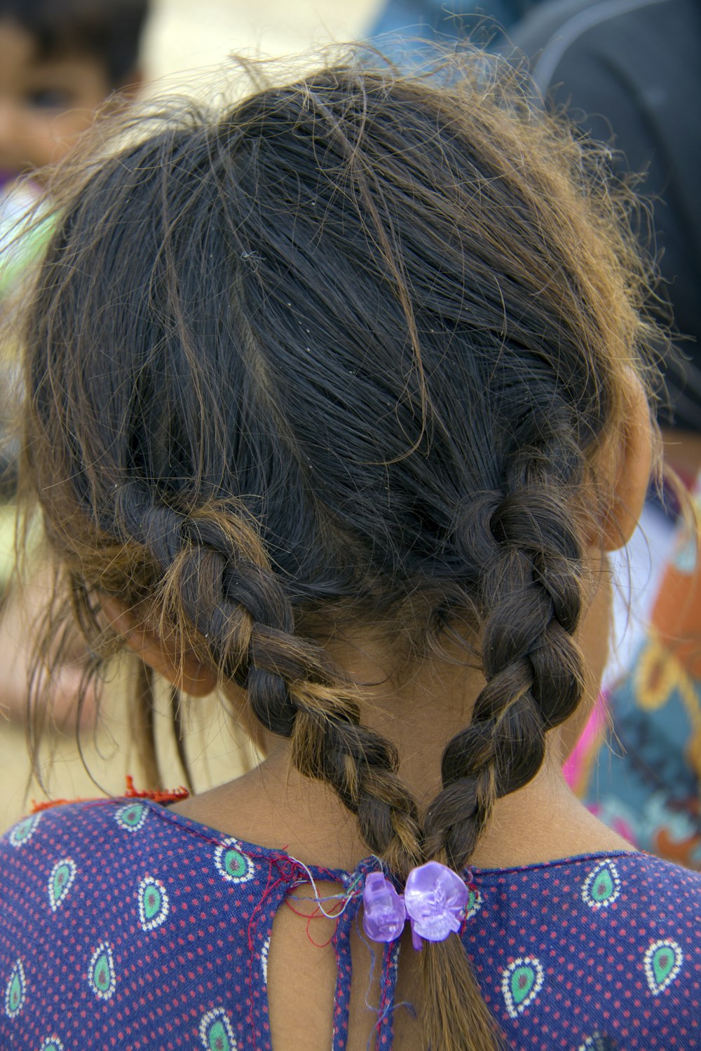 Frau im bunten Kleid mit geflochtenen Haaren