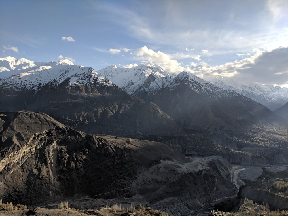 snow capped mountain ranges under blue and white cloudy sky