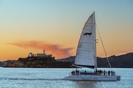 Guests enjoying a sunset sail, laughter and warm light reflecting off the water.