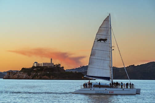 A friendly captain assisting a group of friends boarding a modern sailboat at sunset in Buenos Aires