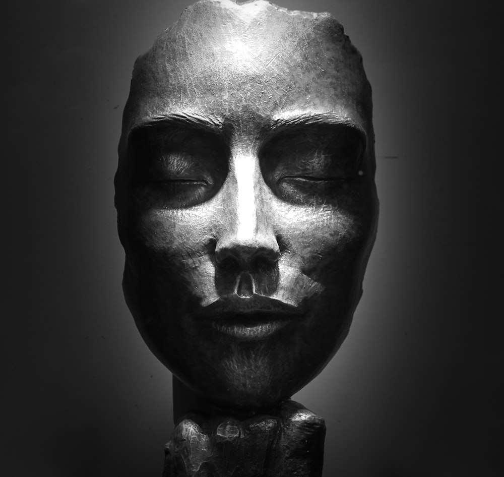 灰色の陶器の女性の顔の胸像の置物