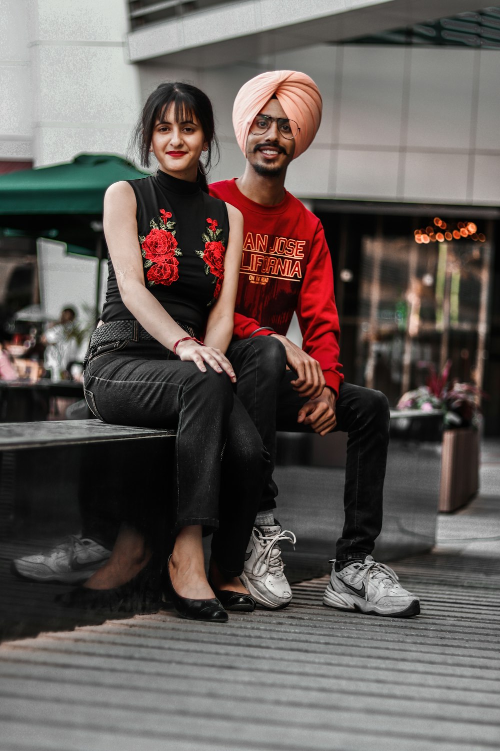 smiling man and woman sitting on bench near outdoor during daytime