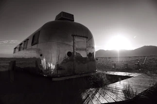 A sleek modern trailer parked in a scenic outdoor setting at sunset.
