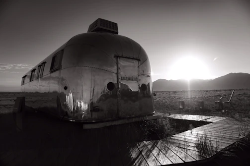 A sleek modern trailer parked in a scenic outdoor setting at sunset.