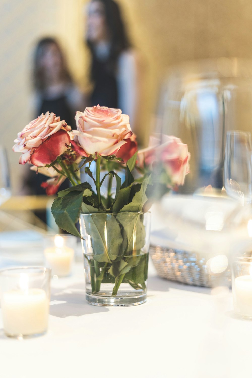 white roses in drinking glass