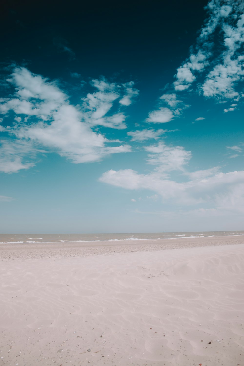 brown sand under white clouds