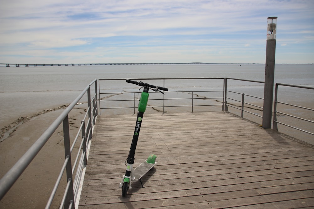 black and green kick scooter on brown wooden dock