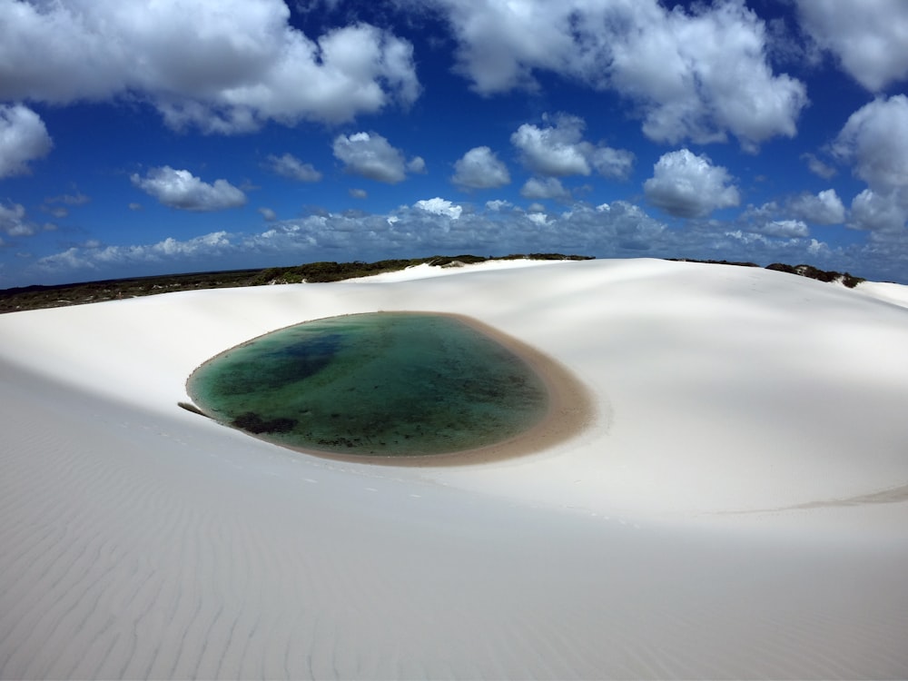 una gran masa de agua sentada en la parte superior de una playa de arena