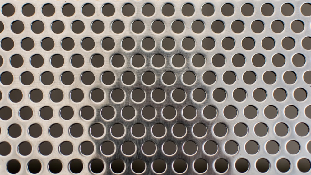 the shadow of a person standing in front of a metal grate