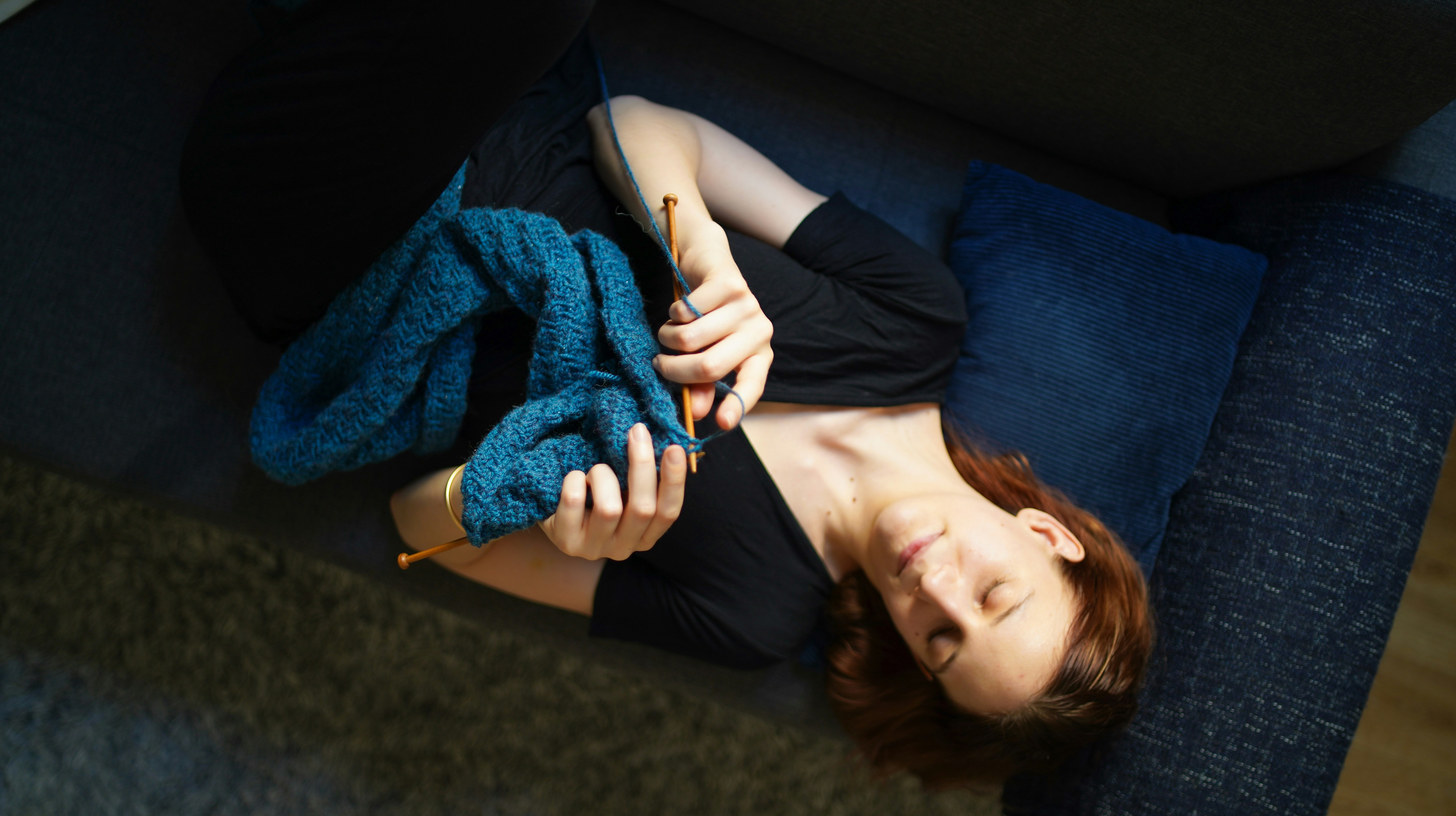 mujer tejiendo en el sofa @triconautes